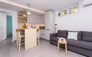 a living room and kitchen with a couch and a table at Happy Apartments Baška in Baška