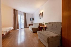 a living room with a couch and a bed and a table at Apartments Knežević in Neum
