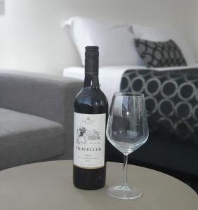 a bottle of wine and a wine glass on a table at Charles Sturt Motor Inn in West Wyalong