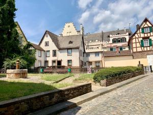 een groot wit huis met een kasteel op de achtergrond bij Fewo Am Brunnen in Rüdesheim am Rhein