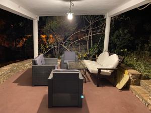 a group of chairs sitting on a patio at night at Casa do Milho in Carvoeiro