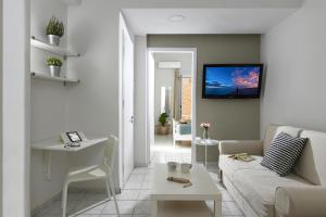 a living room with a couch and a tv on the wall at Stylish Apartment by City Center B in Heraklio