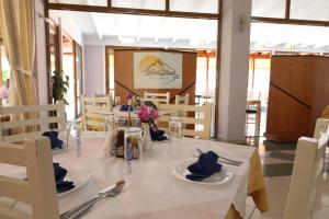 a dining room with a white table with blue napkins at Hotel Tatzati in Sarandë