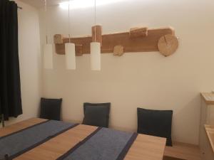 um quarto com uma mesa com cadeiras e um lustre em Alloggio Casa Talvena XL em Longarone