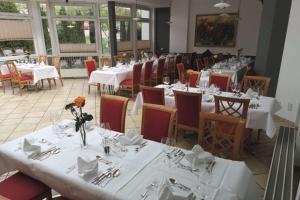 un comedor con mesas blancas y sillas con flores. en Hotel Empfinger Hof, Sure Hotel Collection by Best Western, en Empfingen
