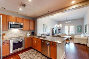 a kitchen with wooden cabinets and a living room at Redfish Village Condos in Santa Rosa Beach