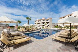 uma piscina no resort com espreguiçadeiras e guarda-sóis em Solmar Resort em Cabo San Lucas