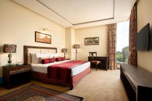 a hotel room with a bed and a window at Ramada by Wyndham Islamabad in Islamabad