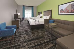 a hotel room with a bed and a couch at La Quinta by Wyndham Tyler South in Tyler