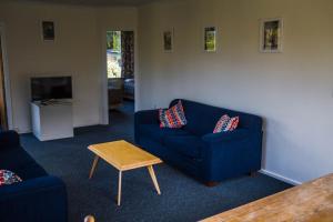 una sala de estar con 2 sofás azules y una mesa. en The Camp - Lake Hawea en Lake Hawea