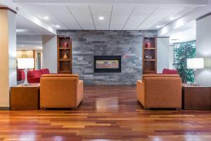 a waiting room with chairs and a fireplace at Ramada Plaza by Wyndham Montreal in Montreal