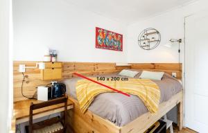a bedroom with a wooden bed with a yellow blanket at The Cabin at Zwolle Centraal in Zwolle