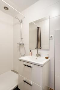 a white bathroom with a sink and a mirror at The Cabin at Zwolle Centraal in Zwolle