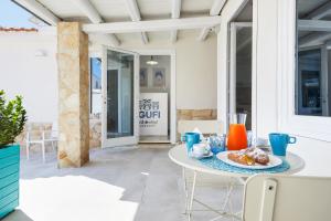 a table with a plate of food on a patio at I Gufi Bed & Breakfast Marzamemi in Marzamemi