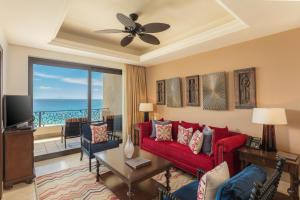 a living room with a red couch and a view of the ocean at Grand Solmar Land's End Resort & Spa in Cabo San Lucas