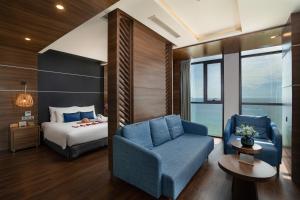 ein Schlafzimmer mit einem Bett, einem Sofa und einem Stuhl in der Unterkunft HAIAN Beach Hotel & Spa in Đà Nẵng