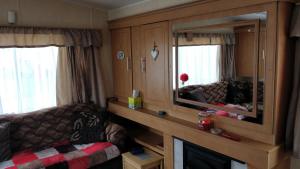 a living room with a couch and a mirror at Golden Sands Ingoldmells (Atlantis) in Skegness