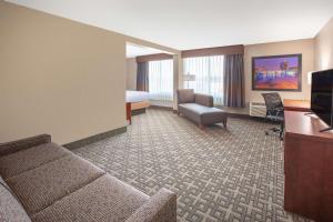 a hotel room with a couch and a bed at Baymont by Wyndham Grand Rapids Near Downtown in Grand Rapids