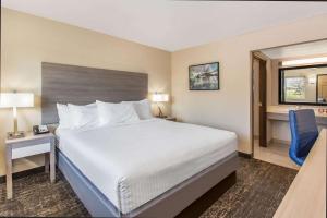 a hotel room with a bed and a desk and a window at Days Inn Merced / Yosemite Area in Merced