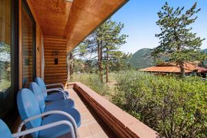 un porche con sillas azules en una casa en Rocky Mountain High, en Estes Park