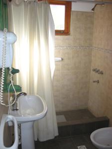 y baño con lavabo y ducha. en Cabañas Lorien en Esquel