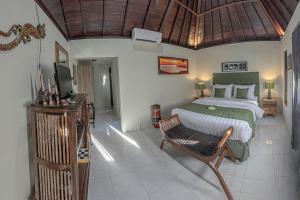 a bedroom with a bed and a television in it at Tirta Bali Villa in Jimbaran