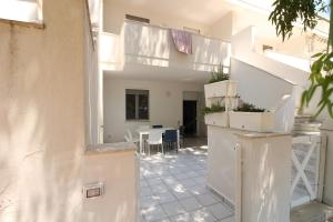 a white house with a kitchen and a dining room at Sabbia e Mare in Torre San Giovanni Ugento