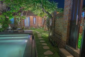 einen Hinterhof mit Pool und Ziegelwand in der Unterkunft Tirta Bali Villa in Jimbaran + 37 Fotos
