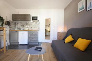a living room with a couch and a table at expat renting - Le Sophia - Casino Barrière - Parking in Toulouse