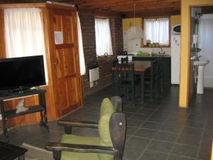 a living room with a tv and a kitchen at Cabañas Lorien in Esquel