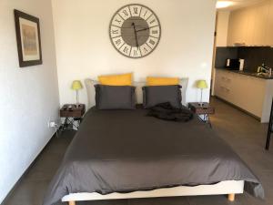 1 dormitorio con 1 cama grande y reloj en la pared en Amazing Studio In Lausanne Close To Epfl Unil en Ecublens