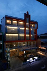 a building with a sign in front of it at Winstar Hotel in Pekanbaru