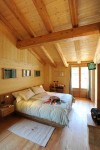 um quarto com uma cama num quarto com tectos em madeira em HIBOU chambres & spa - Cogne em Cogne