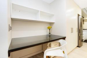 cocina blanca con escritorio y silla blanca en Darwin Waterfront Luxury Suites en Darwin