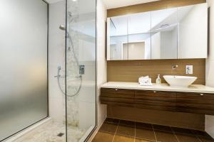 a bathroom with a sink and a shower at Darwin Waterfront Luxury Suites in Darwin