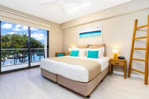 a bedroom with a large bed and a large window at Darwin Waterfront Luxury Suites in Darwin