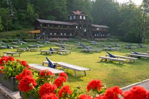 un gruppo di tavoli da picnic di fronte a un grande edificio di Inselhotel Faakersee a Faak am See