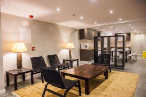 a living room with chairs and a table and a kitchen at Rossio Suites in Lisbon