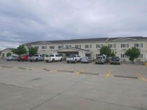 a large building with cars parked in a parking lot at FairBridge Inn & Suites Williston in Williston