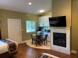 a room with a bed and a fireplace with a table and chairs at Sea Breeze Inn - Pacific Grove in Pacific Grove