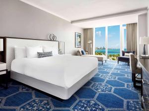 a bedroom with a large white bed and a large window at Fairmont El San Juan Hotel in San Juan