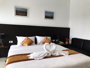 a bedroom with a bed with a heart shaped towel at P Bliss hotel in Phayao