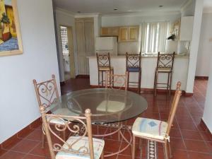 cocina con mesa de cristal y sillas en Hotel Venezia, en Mazatlán