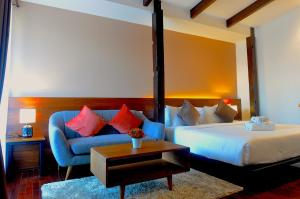 um quarto com uma cama e um sofá azul em The Eight Ratvithi House em Chiang Mai