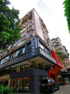 广州Paco Hotel BeiJing Road Metro Guangzhou-Free Shuttle Bus For Canton Fair的一栋建筑前停着一辆车