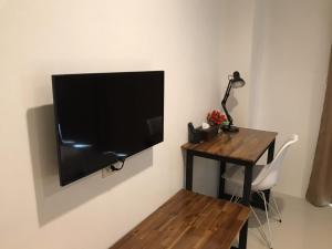 a flat screen tv hanging on a wall next to a desk at P Bliss hotel in Phayao