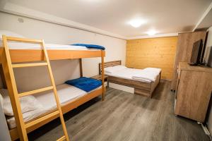 a room with two bunk beds and a television at Apartments Zvoh, Krvavec, Ski-in, Ski-out in Cerklje na Gorenjskem