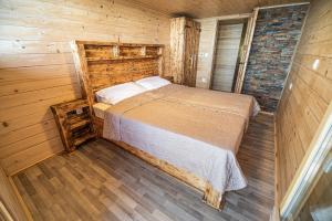 ein Schlafzimmer mit einem Bett in einer Holzhütte in der Unterkunft Apartments Zvoh, Krvavec, Ski-in, Ski-out in Cerklje na Gorenjskem