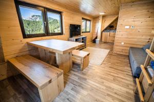 una habitación con una mesa y un sofá en una cabaña en Apartments Zvoh, Krvavec, Ski-in, Ski-out en Cerklje na Gorenjskem