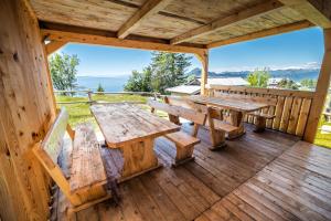 a wooden deck with a table and benches on it at Apartments Zvoh, Krvavec, Ski-in, Ski-out in Cerklje na Gorenjskem